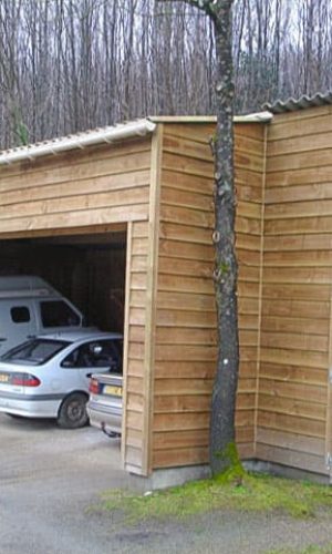 Hangar garage avec ferme moisée sur poteau, ossature bois avec clin douglas traité classe 3 ; partie rangement fermé dito avec porte ; couverture en plaque fibre ciment flammé.