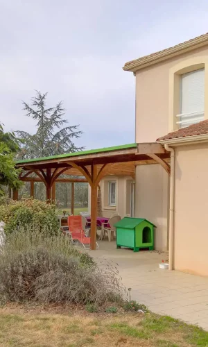 Aménagement d'une pergola couverte en pin traité classe 4 ; avec lien cintré ; toiture par plaque polycarbonate.